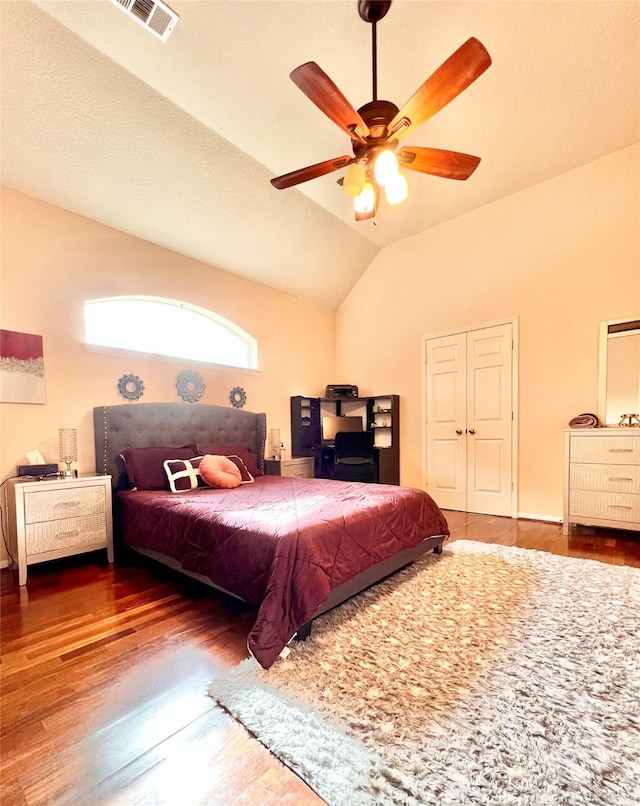 bedroom featuring a ceiling fan, vaulted ceiling, wood finished floors, and visible vents