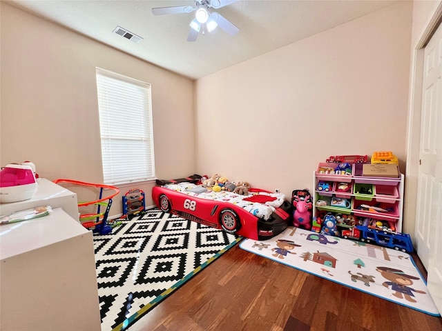 rec room featuring wood finished floors, visible vents, and ceiling fan