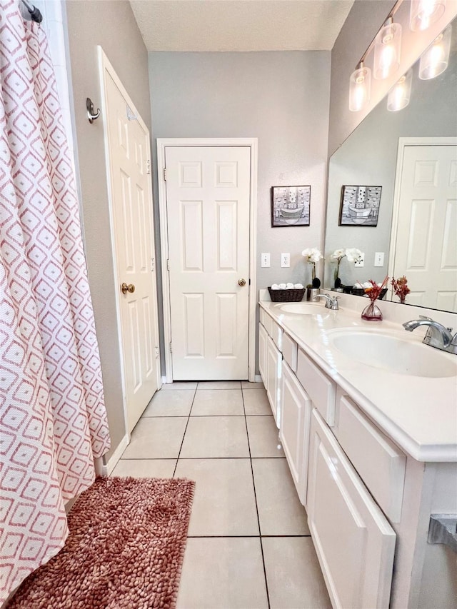 bathroom with tile patterned floors, double vanity, and a sink