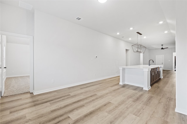 kitchen with visible vents, light countertops, recessed lighting, light wood-style flooring, and a kitchen island with sink