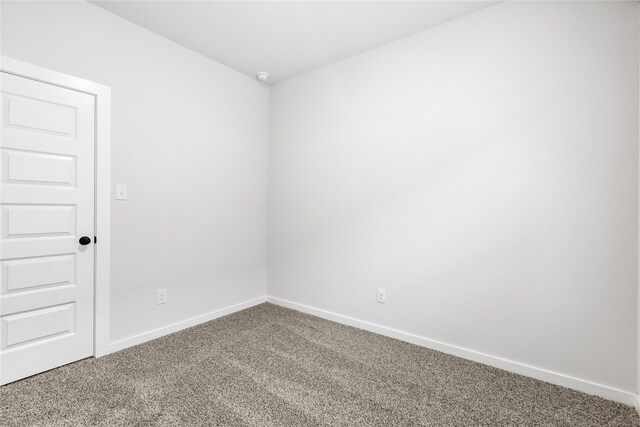 spare room featuring carpet and baseboards