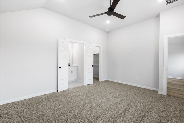 unfurnished bedroom with visible vents, light colored carpet, baseboards, and vaulted ceiling