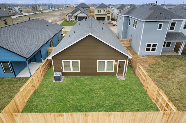 back of house with a residential view, central AC unit, and a shingled roof