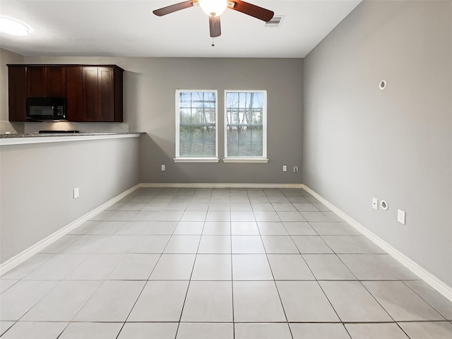 interior space with visible vents, ceiling fan, baseboards, dark brown cabinetry, and black microwave