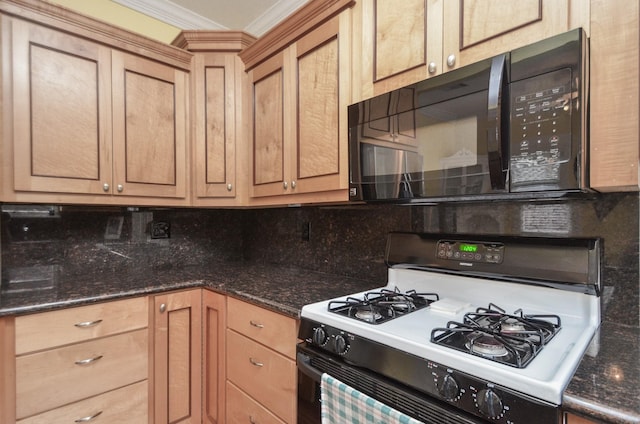 kitchen featuring tasteful backsplash, black microwave, dark stone counters, ornamental molding, and gas range oven