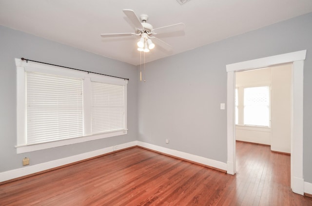 spare room featuring wood finished floors, baseboards, and ceiling fan