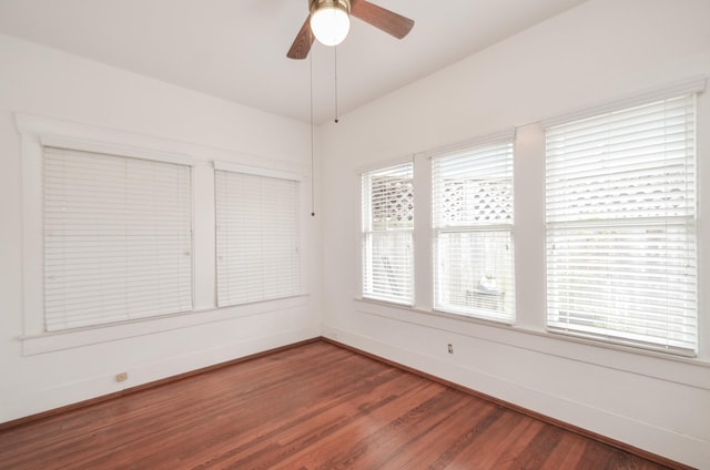 spare room with wood finished floors, baseboards, and ceiling fan