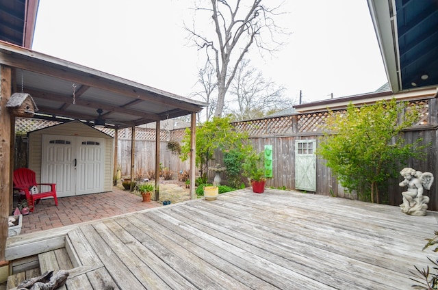 wooden deck featuring a fenced backyard, a patio, a storage shed, and an outdoor structure