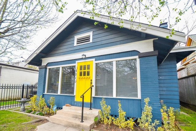 bungalow featuring entry steps and fence