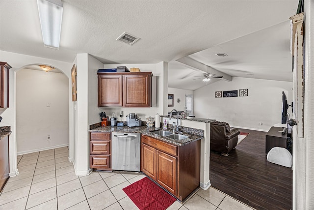 kitchen featuring a ceiling fan, a peninsula, arched walkways, a sink, and stainless steel dishwasher