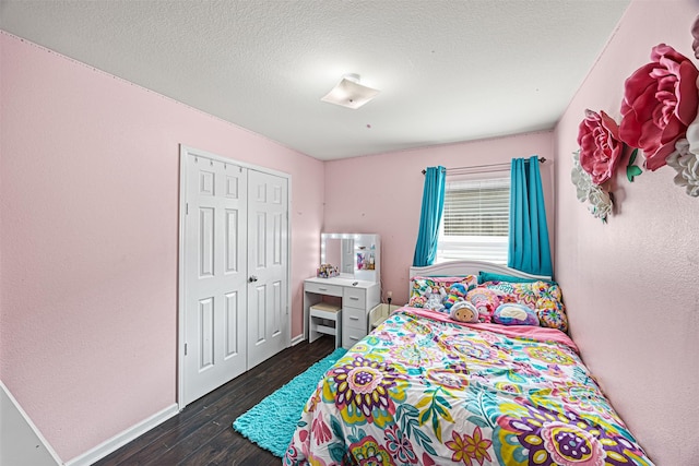 bedroom featuring a closet, baseboards, a textured ceiling, and dark wood finished floors