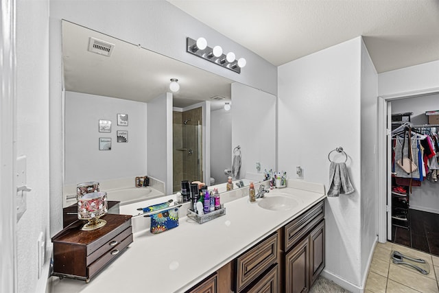 full bathroom featuring vanity, visible vents, a stall shower, tile patterned flooring, and a spacious closet