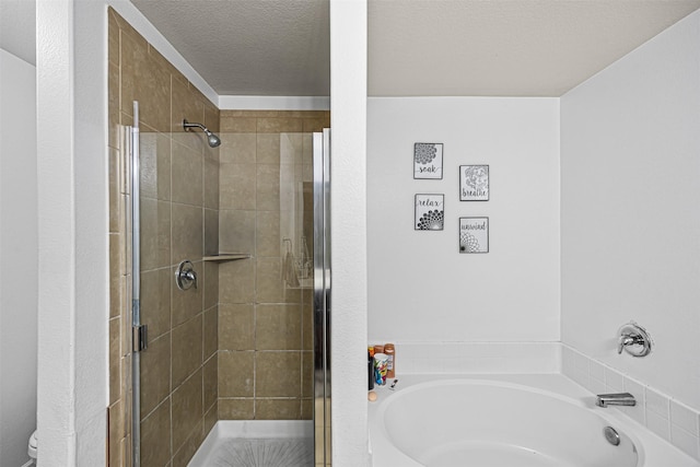 bathroom featuring a bath, a shower stall, a textured ceiling, and toilet