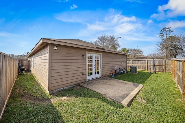 back of house featuring central AC unit, french doors, a lawn, a fenced backyard, and a patio