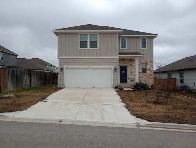 view of front of home featuring board and batten siding, fence, central AC unit, a garage, and driveway