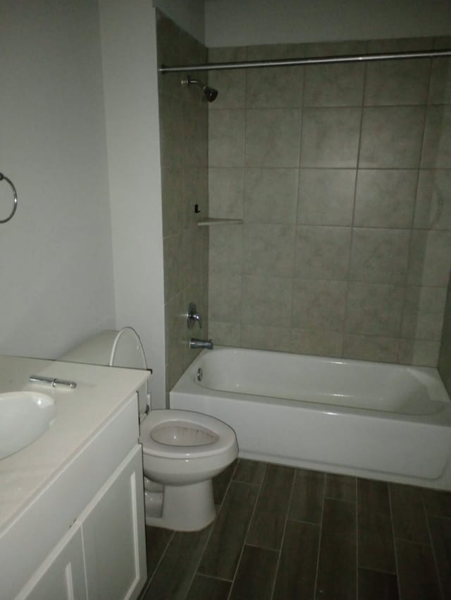 bathroom featuring vanity, shower / washtub combination, toilet, and wood finish floors