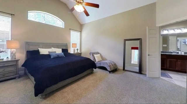 bedroom with light carpet, high vaulted ceiling, ensuite bath, and ceiling fan