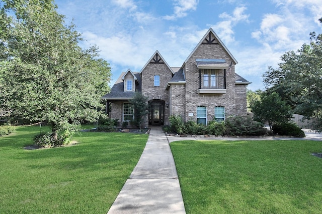 view of front of house featuring a front lawn and brick siding