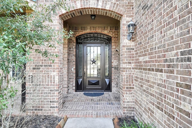 view of exterior entry with brick siding