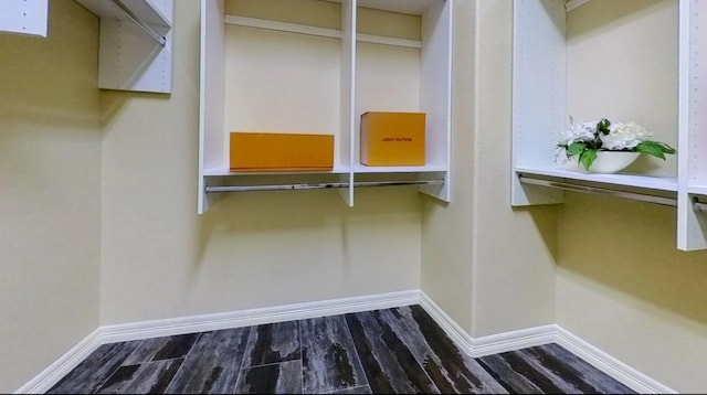 spacious closet with dark wood finished floors