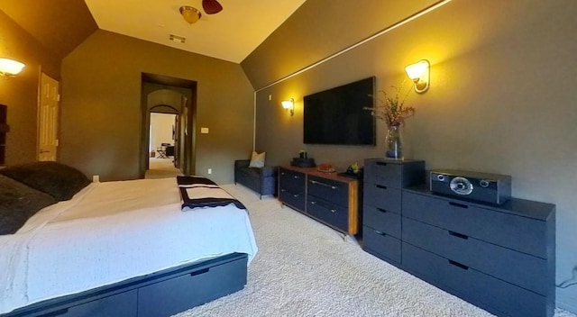 bedroom with vaulted ceiling, light colored carpet, and visible vents