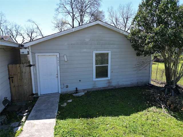 back of house with a lawn and fence