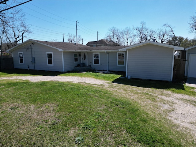 back of property featuring a lawn and driveway