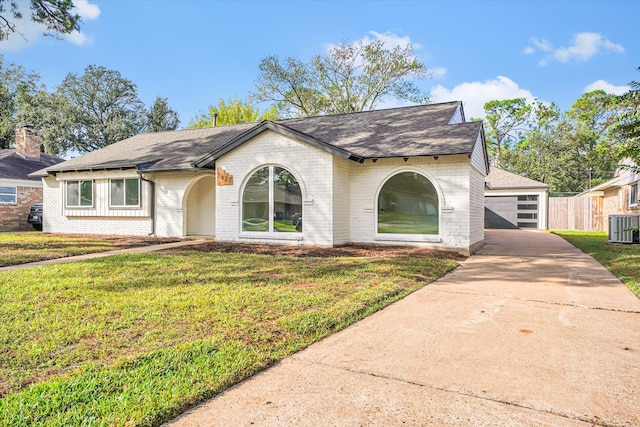 view of front of house with a front yard, fence, central AC unit, and brick siding