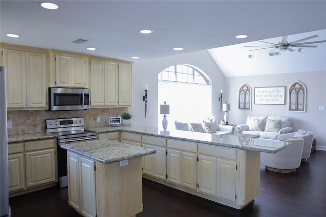 kitchen featuring visible vents, dark wood-type flooring, appliances with stainless steel finishes, a peninsula, and vaulted ceiling