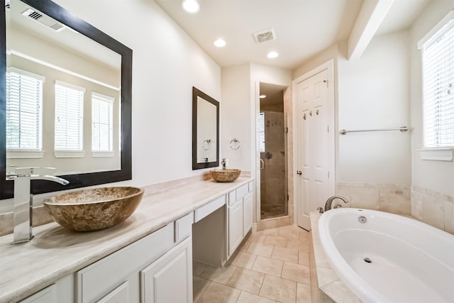 bathroom with a sink, visible vents, a garden tub, and double vanity