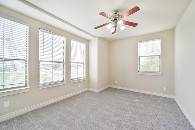 spare room featuring baseboards, carpet floors, and ceiling fan