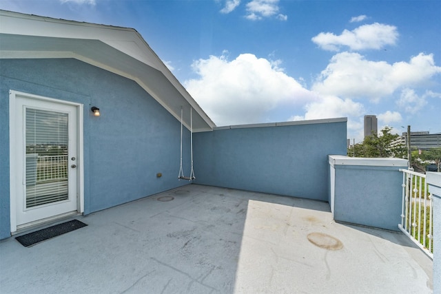 view of patio with a view of city and a balcony