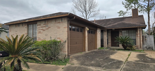 exterior space featuring concrete driveway, an attached garage, and brick siding