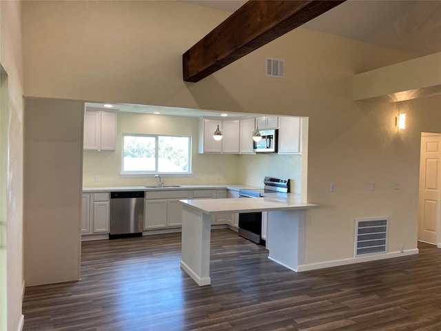 9 Flounder Cir, Freeport, TX 77541 - kitchen with appliances with stainless steel finishes, a peninsula, white cabinets, beam ceiling, and light countertops