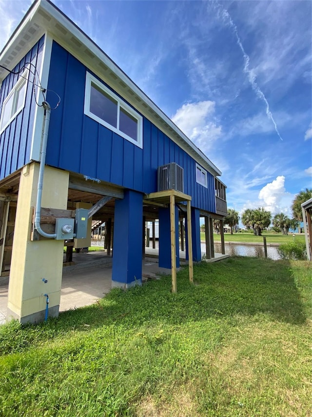 9 Flounder Cir, Freeport, TX 77541 - back of house with a water view, board and batten siding, and a lawn