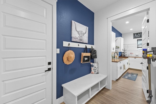 mudroom featuring a sink, recessed lighting, and light wood finished floors