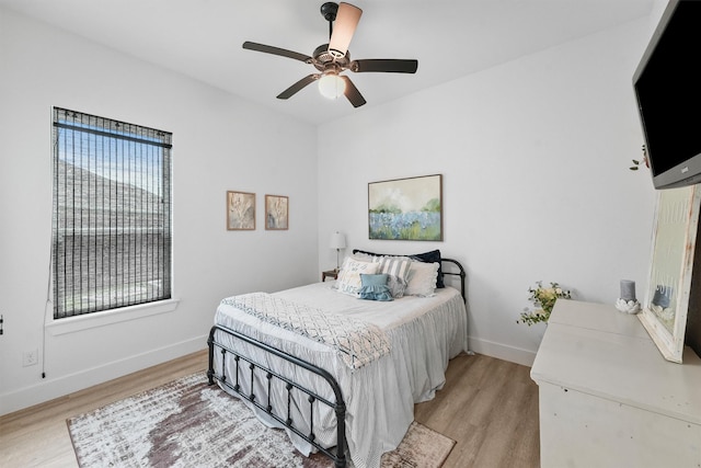 bedroom featuring light wood finished floors, ceiling fan, and baseboards