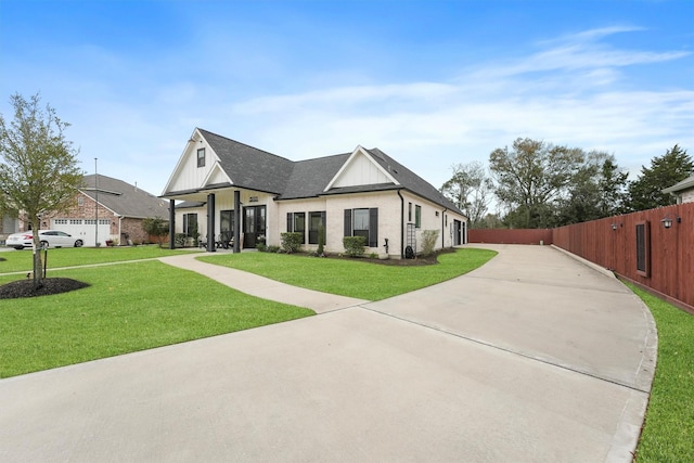 modern farmhouse with driveway, a front lawn, fence, roof with shingles, and board and batten siding