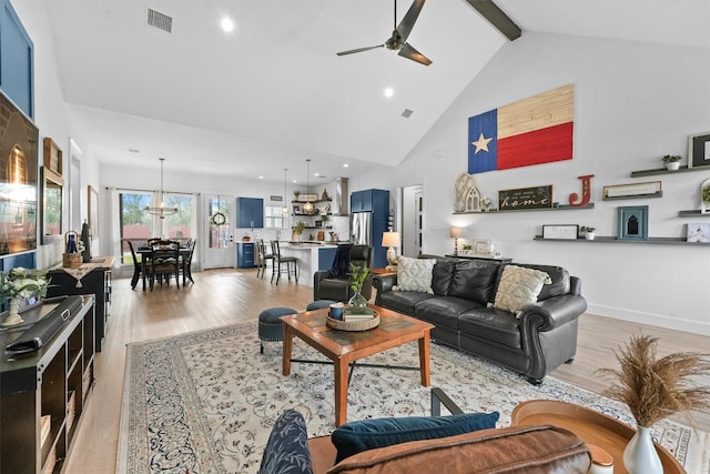 living room with beam ceiling, light wood-style flooring, visible vents, and high vaulted ceiling