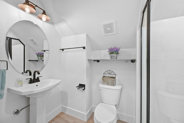 bathroom featuring toilet, baseboards, visible vents, and walk in shower