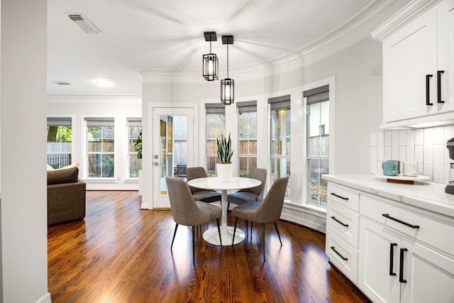 dining space with visible vents, baseboards, dark wood-style flooring, and crown molding