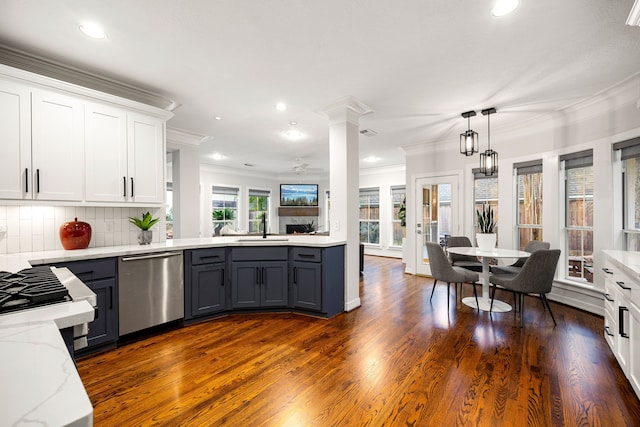 kitchen featuring decorative columns, gray cabinets, a sink, decorative backsplash, and stainless steel dishwasher