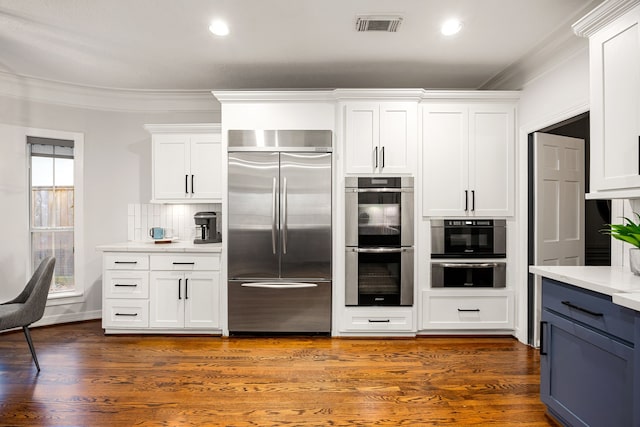 kitchen featuring visible vents, appliances with stainless steel finishes, dark wood-style flooring, and crown molding