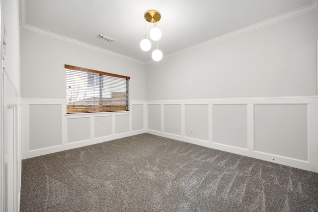 carpeted spare room featuring visible vents, a decorative wall, a wainscoted wall, and ornamental molding