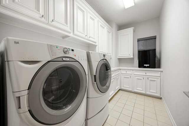 clothes washing area featuring washer and dryer, light tile patterned floors, cabinet space, and baseboards