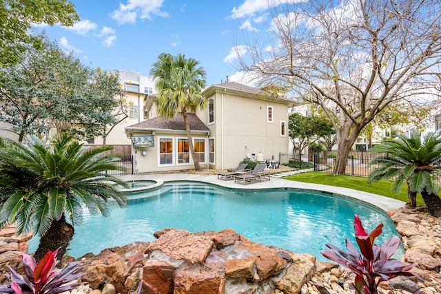 view of swimming pool with a patio area, a fenced in pool, an in ground hot tub, and fence