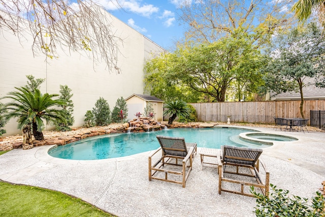 view of pool with a fenced in pool, a shed, a fenced backyard, an in ground hot tub, and a patio