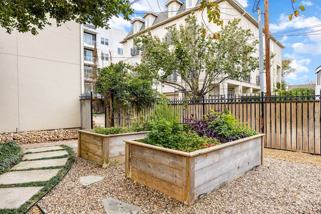 exterior space featuring a garden and fence