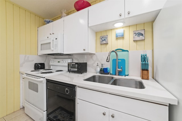 kitchen featuring a sink, white cabinetry, white appliances, light tile patterned flooring, and light countertops