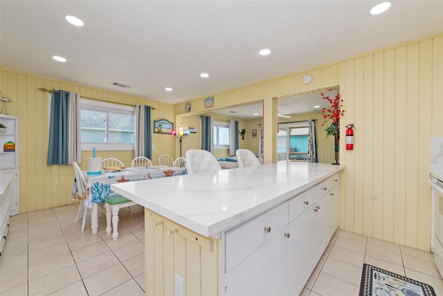 kitchen featuring light tile patterned floors, light stone countertops, visible vents, a peninsula, and recessed lighting